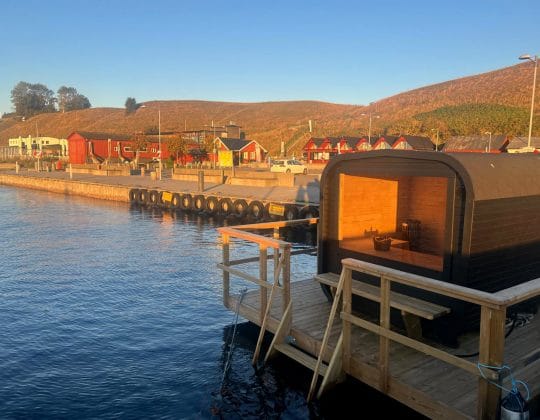 Insyn i en nybyggd bastu i hamnmiljö i solnedgång